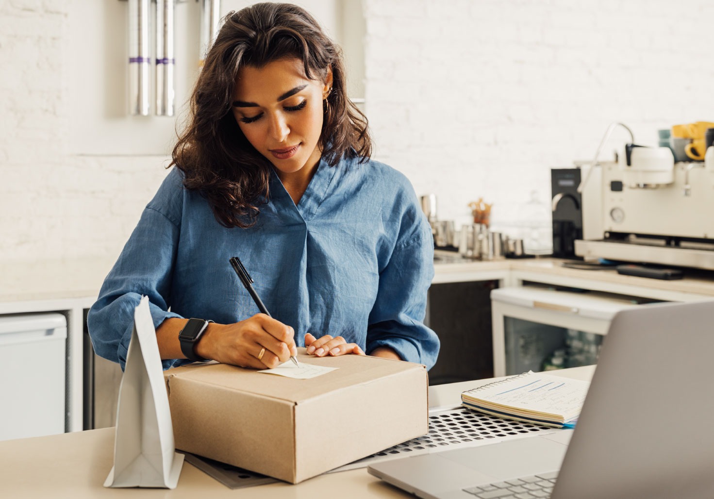 Una mujer agregando una etiqueta a una caja